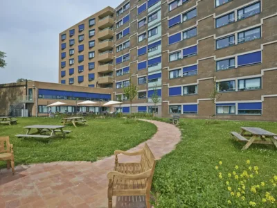 Foto van het interieur van een appartement in De Moerberg, met een gezellige zithoek en eettafel. Het raam biedt een mooie uitzicht op het groen.